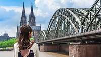 Chinesische Touristin blickt auf Deutzer Brücke und den Kölner Dom