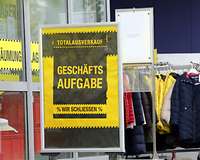 Schild "Geschäftsaufgabe" vor einem Kleidergeschäft