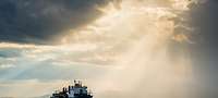 Merchant ship at sea with beam of light 