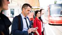 Businessman and other passengers waiting at a bus stop