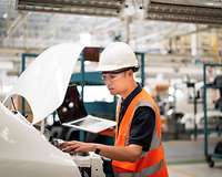 Ingenieur mit Laptop in chinesischer Autofabrik