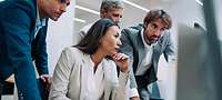 Concerned businessmen and -women look into a computer screen