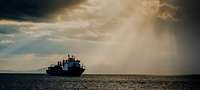 Merchant ship at sea with beam of light 