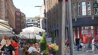 Straße in der Innenstadt mit Passanten und Straßencafés