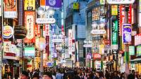 Volle Einkaufsstraße in Tokio (Shibuya Shopping District) mit viel Leuchtreklame