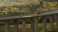 Ein roter LKW fährt auf der Vinxtbachtalbrücke in der Eifel